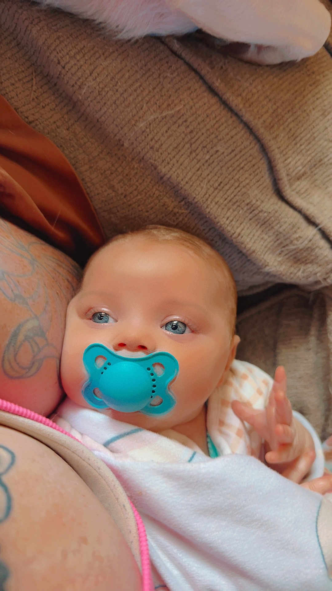Malina is registered to the contest to win money with this photo: baby, pacifier, blue_eyes, blanket, tattoo, arm, couch, soft_texture, infant, closeup, skin, hand, comfort, resting, indoor, peaceful, person, newborn, cozy, portrait