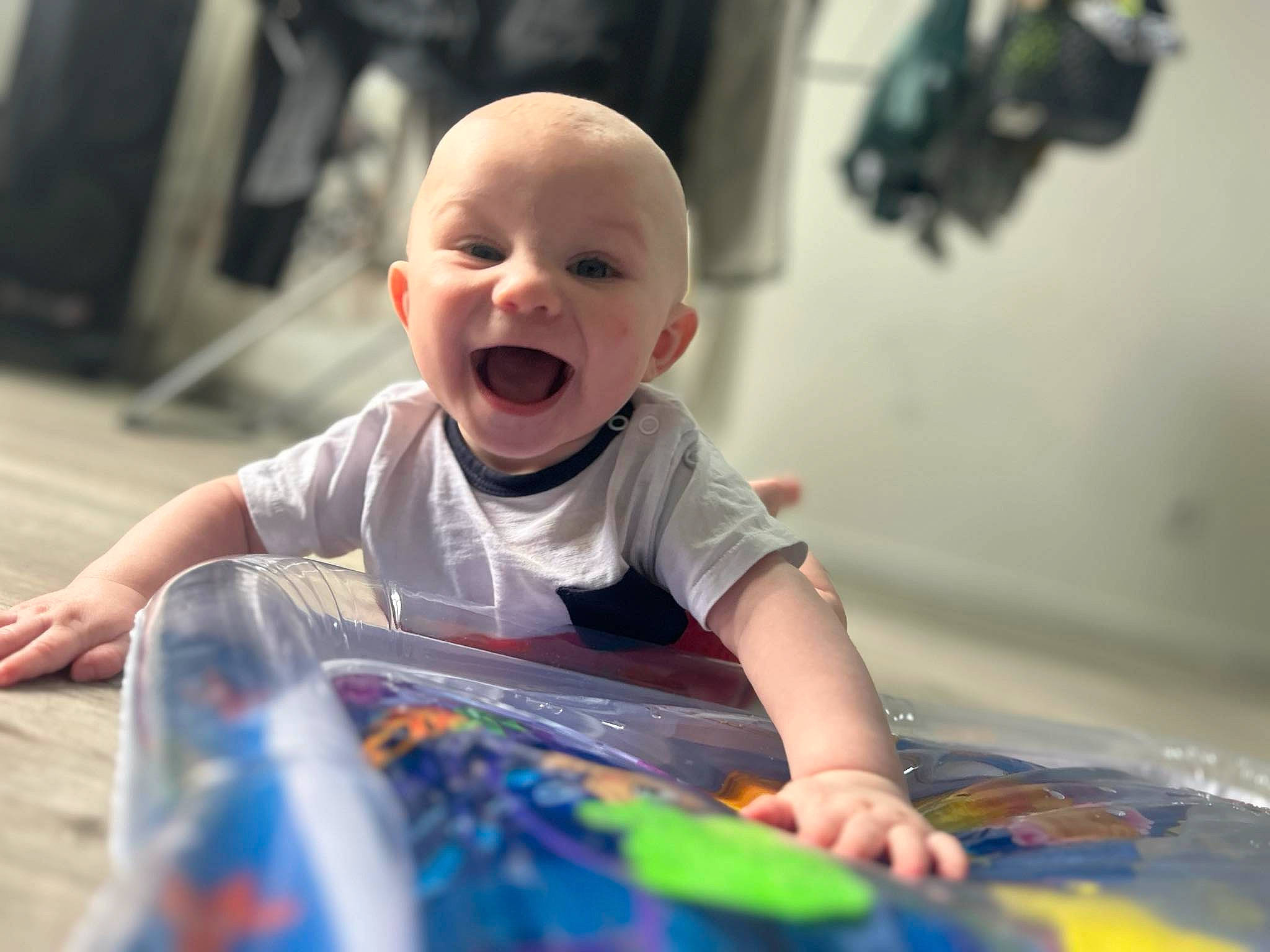 Scott a rejoint le concours — aidez-le/la à gagner de superbes lots ! baby, baby_playing_with_toys, baby_toddler_clothing, child, face, facial_expression, flooring, fun, happy, laugh, leisure, person, play, recreation, room, sitting, smile, t_shirt, toddler, toy