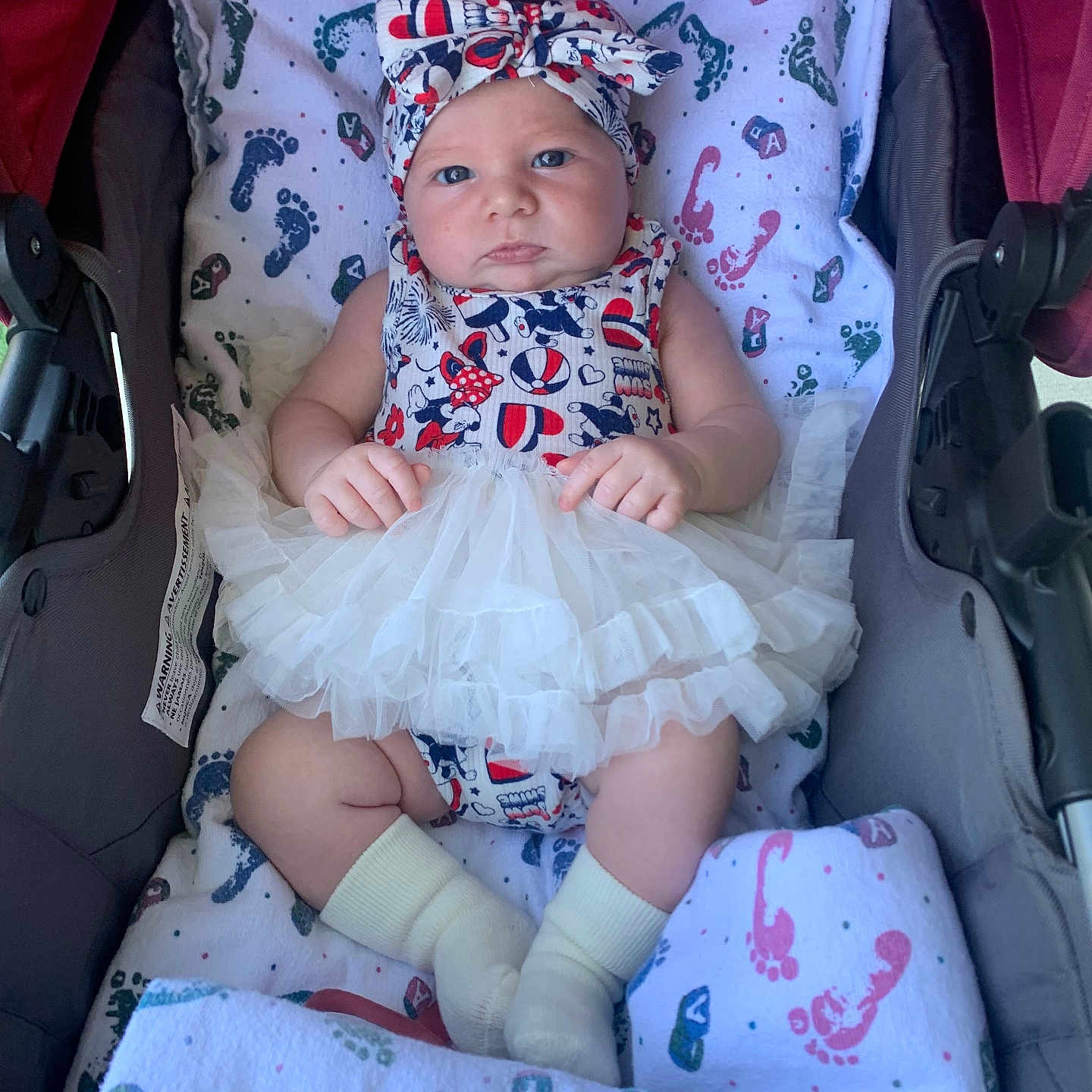 Saydi is registered to the contest to win money with this photo: adorable, baby, babywear, blanket, child, closeup, clothing, comfort, cute, footprints, headband, indoors, infant, patterned, portrait, resting, socks, stroller, tutu, young