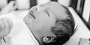 Luca joined the competition — help win amazing prizes! newborn, baby, infant, sleeping, smiling, black_and_white, portrait, close_up, face, head, hair, crib, blanket, soft_focus, peaceful, resting, cute, indoors, person, child