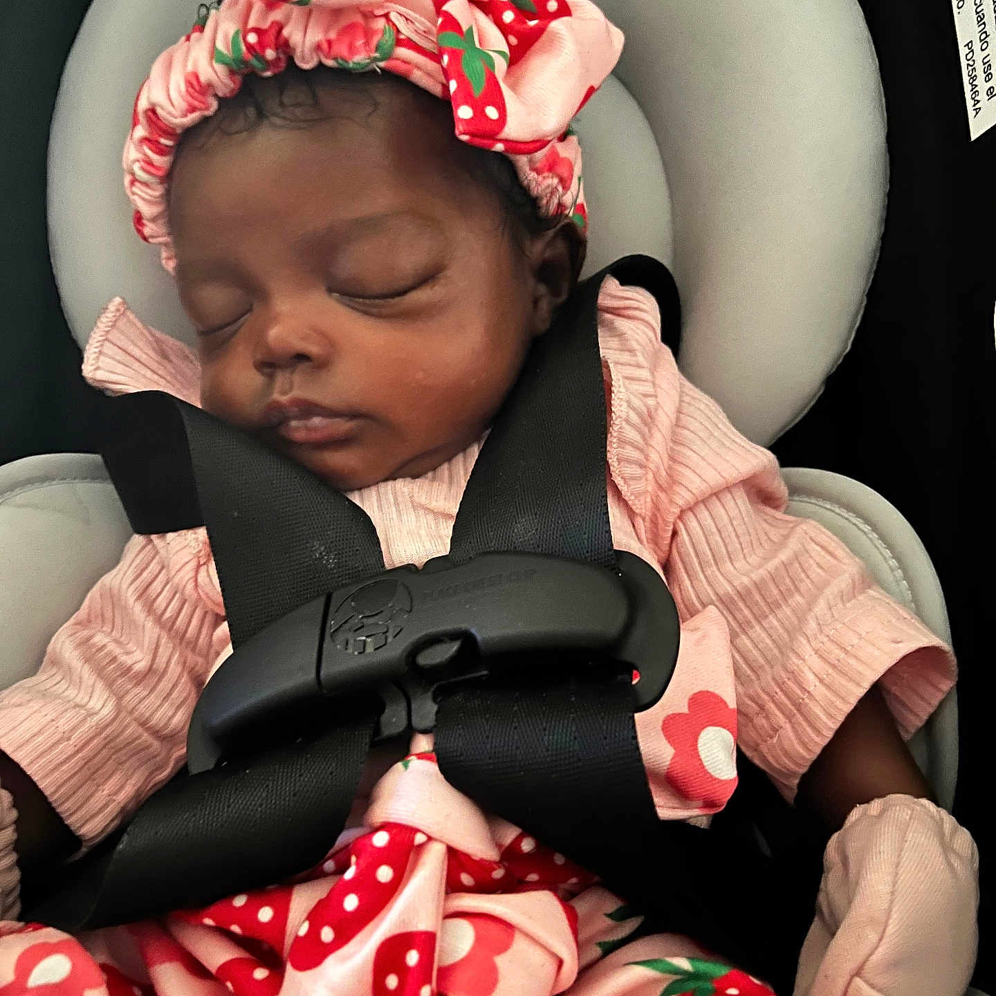Eva Marie is registered to the contest to win money with this photo: baby, infant, sleeping, car_seat, harness, strawberry, bow, headband, pink_outfit, dress, blanket, portrait, face, closed_eyes, peaceful, indoors, vehicle, safe, cushion, photography