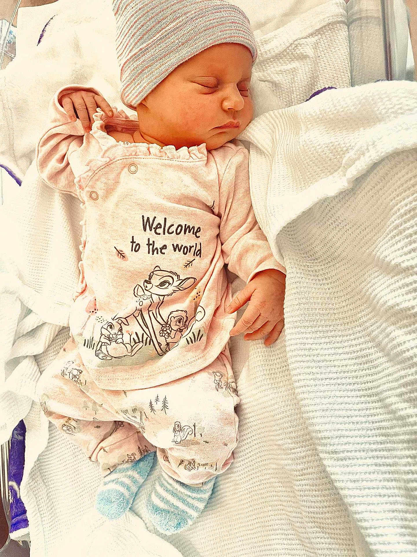 Paisley is registered to the contest to win money with this photo: newborn, baby, sleeping, pajamas, hat, blanket, bed, infant, clothing, cute, soft, striped_socks, cozy, resting, peaceful, child, portrait, indoors, sleep, small