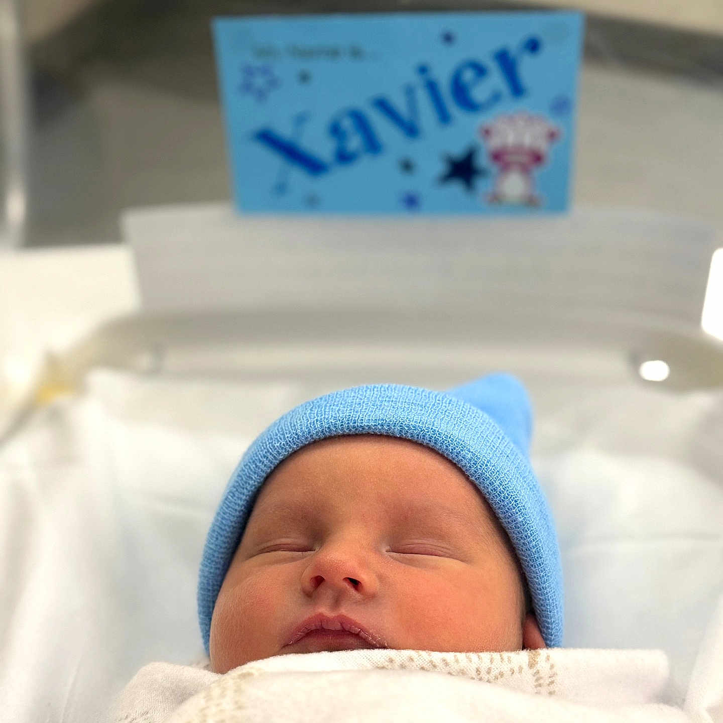Xavier joined the competition — help win amazing prizes! newborn, baby, sleeping, blue_hat, blanket, hospital, bassinet, infant, cute, cozy, portrait, child, peaceful, resting, indoors, soft_light, name_card, closeup, wrapped, sleep
