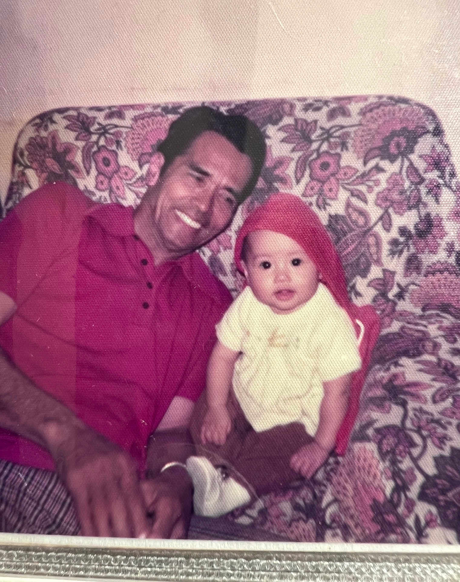 Cleopatra is registered to the contest to win money with this photo: man, baby, child, smile, red_shirt, red_hat, floral_couch, vintage_photo, indoor, portrait, sitting, family, happy, people, pattern, fabric, casual, retro, candid, home