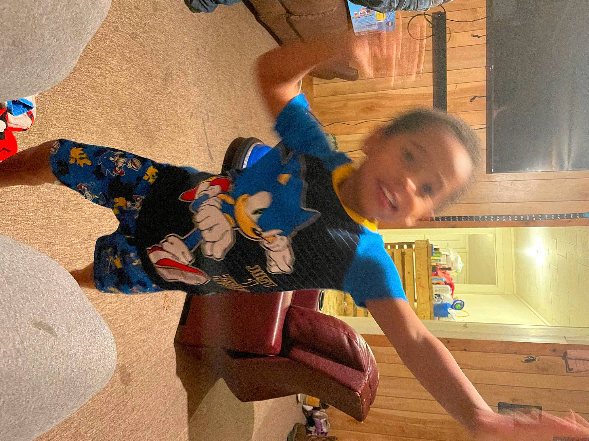 Xavier is registered to the contest to win money with this photo: blue, child, electric_blue, flooring, fun, happy, head, human_leg, knee, leg, leisure, person, play, room, shorts, sitting, smile, sock, thigh, toddler