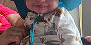 Elijah joined the competition — help win amazing prizes! baby, child, smile, hat, blue_hat, pajamas, animal_print, hand, indoor, natural_light, person, face, cute, infant, clothing, sitting, closeup, cozy, happy, portrait