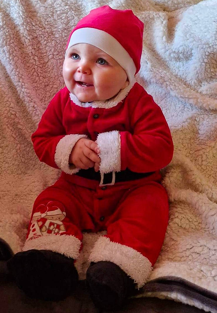 Maylon participe au concours pour gagner de l'argent avec cette photo : baby, baby_toddler_clothing, child, comfort, face, facial_expression, head, headgear, headwear, human_body, lap, leg, outerwear, person, red, skin, sleeve, smile, standing, textile