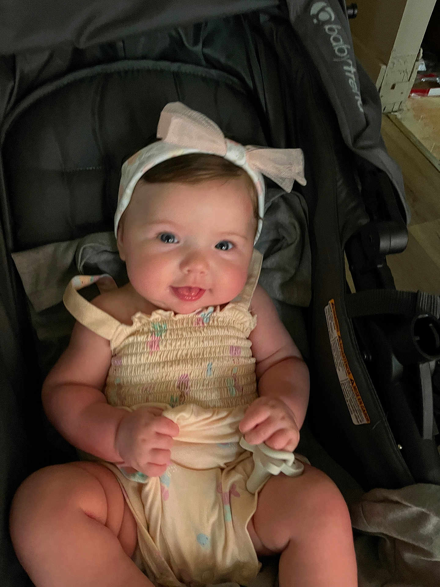 Annabella is registered to the contest to win money with this photo: baby, infant, smiling, headband, romper, stroller, child, cute, chubby, indoors, person, happy, face, legs, hands, sitting, clothing, accessory, babygear, soft