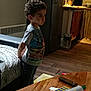 Anis participe au concours pour gagner de l'argent avec cette photo : child, boy, curly_hair, indoor, living_room, kitchen, toy, cash_register, remote_control, wooden_table, couch, blanket, floor, water_bottles, cabinet, shirt, jeans, standing, puffed_cheeks, hands_behind_back