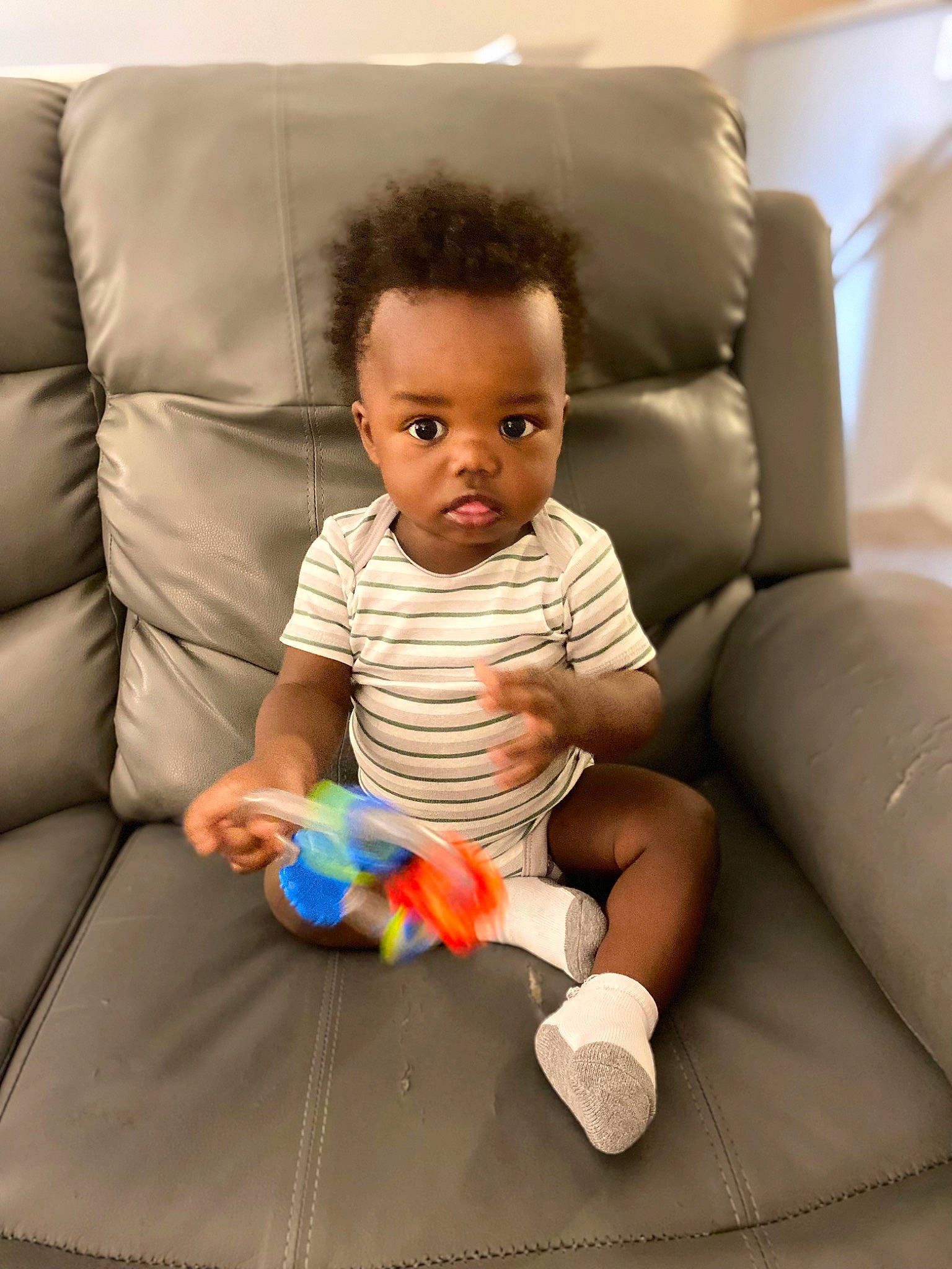 Dameir is registered to the contest to win money with this photo: baby, baby_playing_with_toys, baby_toddler_clothing, cheek, comfort, couch, eye, face, finger, flooring, fun, head, human, mouth, nose, people, person, sitting, skin, smile