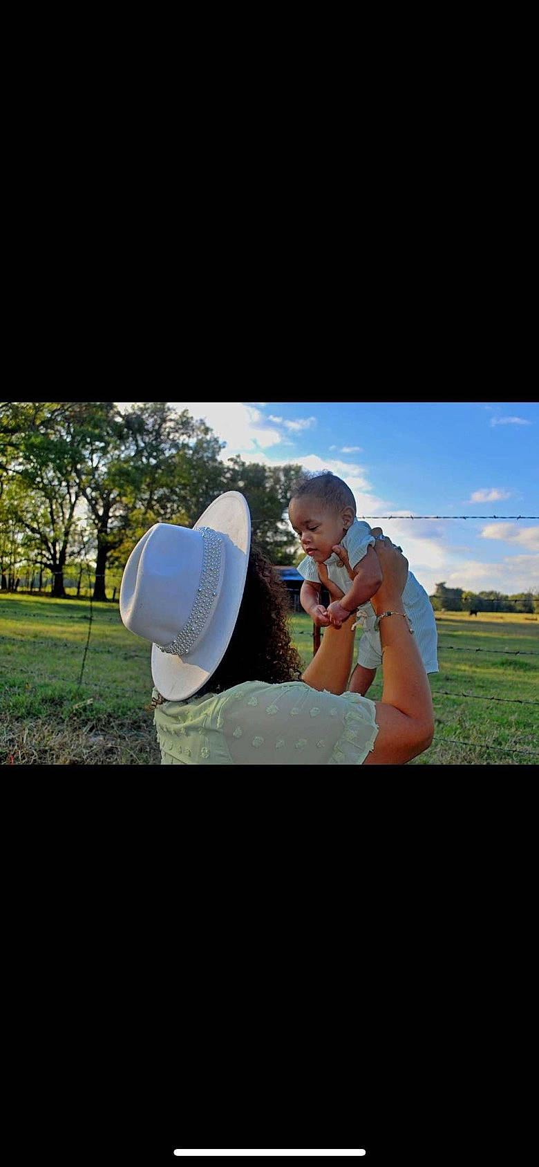 Asher is registered to the contest to win money with this photo: baseball_cap, cap, cloud, flash_photography, fun, gesture, grass, grassland, happy, hat, headgear, landscape, leisure, people_in_nature, person, plant, recreation, sitting, sky, sun_hat