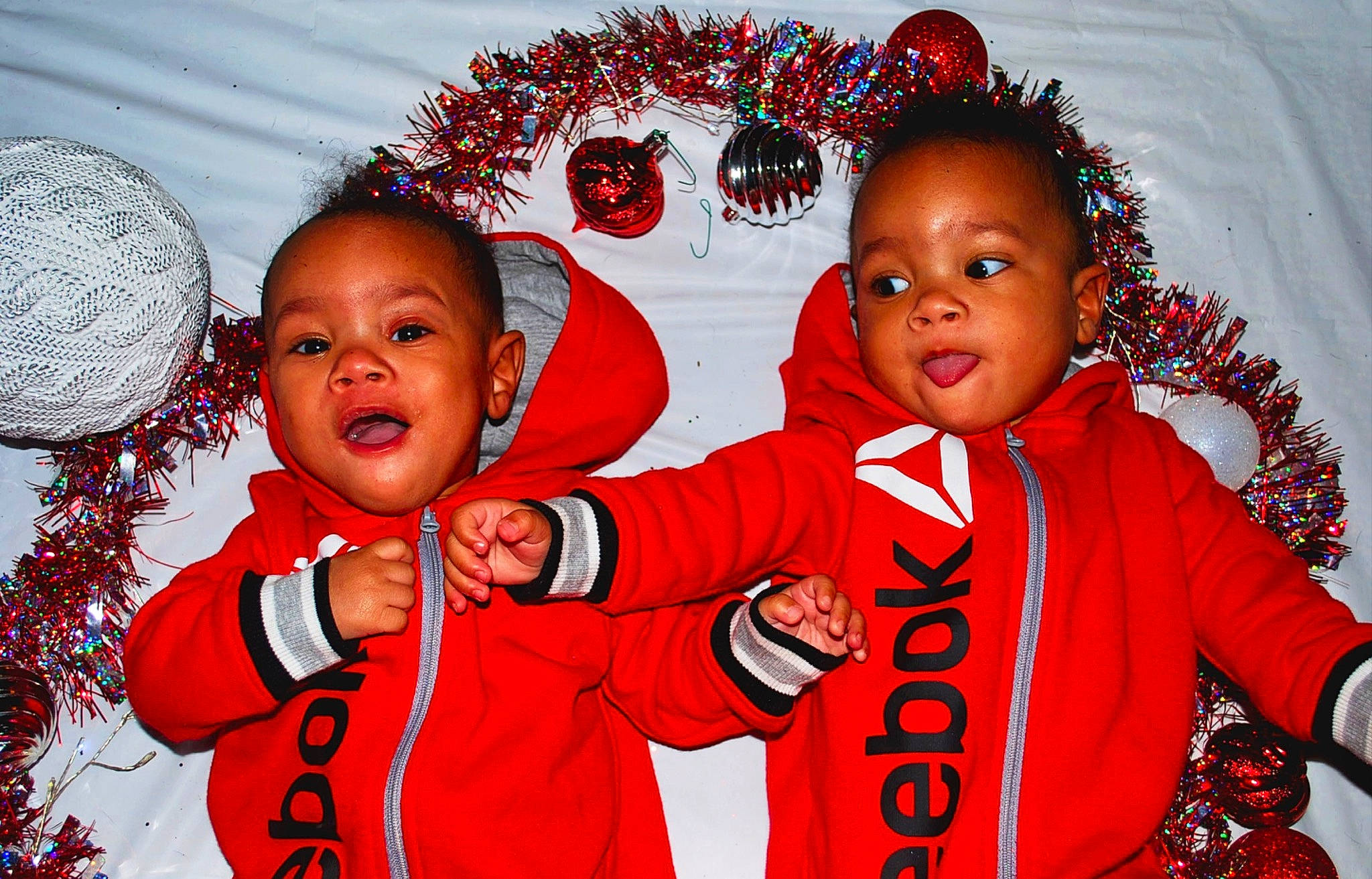 Asher is registered to the contest to win money with this photo: baby_toddler_clothing, child, christmas, christmas_ornament, decoration, event, facial_expression, fun, gesture, happy, holiday, organ, person, photograph, red, sharing, sleeve, smile, toddler, white