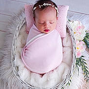 Rebecca a rejoint le concours — aidez-le/la à gagner de superbes lots ! newborn, baby, sleeping, pink_blanket, flower_crown, basket, white_fur, floral_decoration, headband, infant, portrait, cute, peaceful, soft_texture, cozy, resting, indoor, wooden_floor, wrapped, closeup