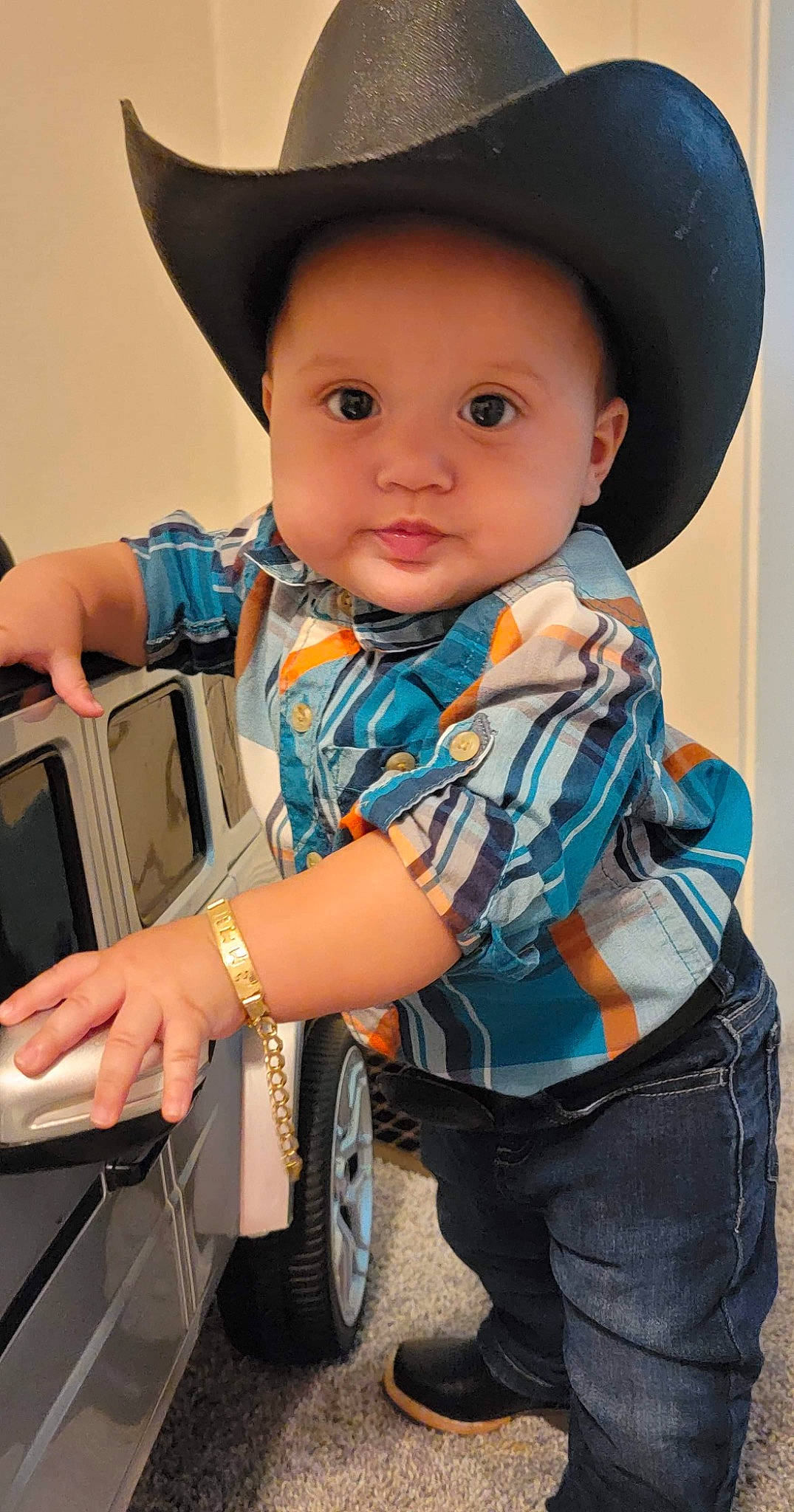 Hector is registered to the contest to win money with this photo: baby, cap, child, clothing, cowboy_hat, electric_blue, finger, flash_photography, gesture, hand, happy, hat, headgear, headwear, neck, person, sleeve, sun_hat, t_shirt, tire