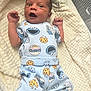 baby, infant, pajamas, cookie_monster, cookie, blanket, clothing, cute, smiling, lying_down, person, child, happy, indoors, fabric, bed, soft, newborn, portrait, expression