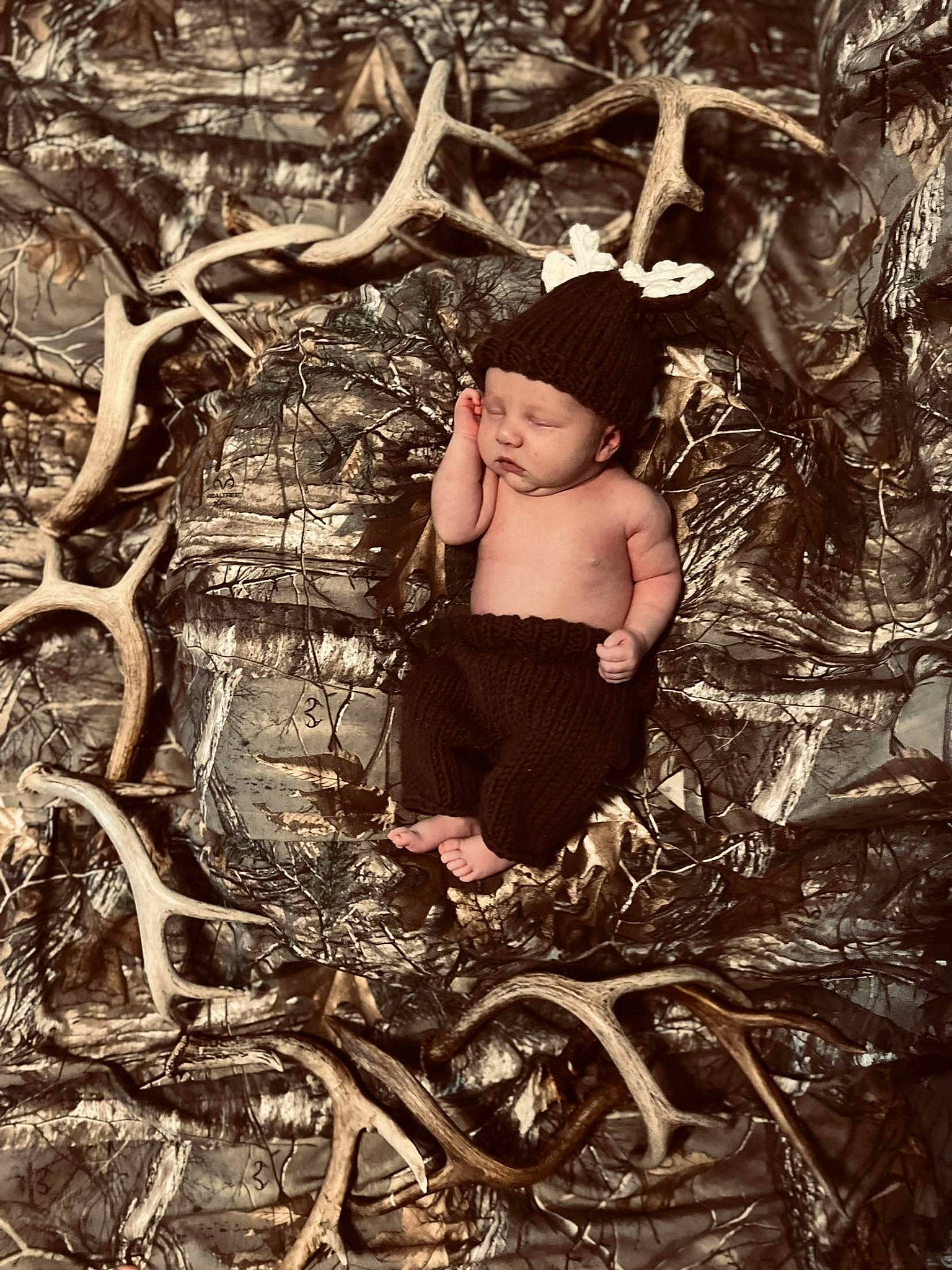 Ian is registered to the contest to win money with this photo: baby, branch, flash_photography, forest, grass, happy, hat, human_body, jungle, monochrome, monochrome_photography, people_in_nature, person, plant, sitting, toddler, tree, trunk, twig, wood