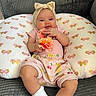 baby, butterfly_pattern, child, clothing, colorful, comfort, couch, cute, flower, headband, home, indoor, infant, person, pillow, portrait, relaxing, smiling, socks, soft_toys