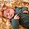 Rowyn joined the competition — help win amazing prizes! baby, infant, child, portrait, lying_down, blanket, plush_blanket, cozy, winter_clothing, hat, bow, green_outfit, indoors, bed, textile, face, eyes, hands, calm, close_up