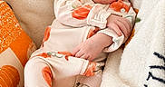 Rowyn is registered to the contest to win money with this photo: baby, newborn, sleeping, portrait, headband, bow, pumpkin, halloween, blanket, cozy, infant, onesie, orange, white, textile, indoors, close_up, peaceful, face, nap