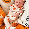 baby, newborn, sleeping, portrait, headband, bow, pumpkin, halloween, blanket, cozy, infant, onesie, orange, white, textile, indoors, close_up, peaceful, face, nap
