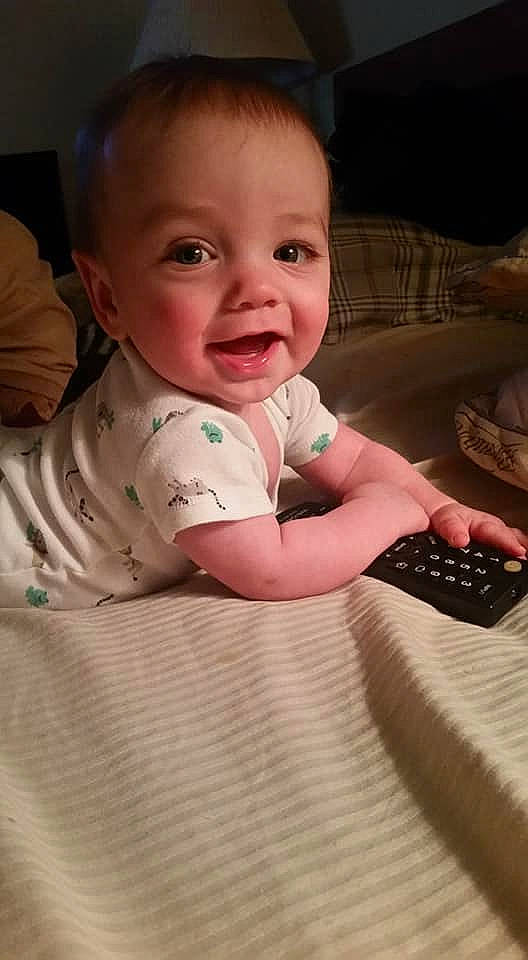 Mark is registered to the contest to win money with this photo: baby, baby_toddler_clothing, cheek, comfort, finger, floor, flooring, hand, happy, head, iris, linens, lip, mouth, nose, person, product, skin, sleeve, smile