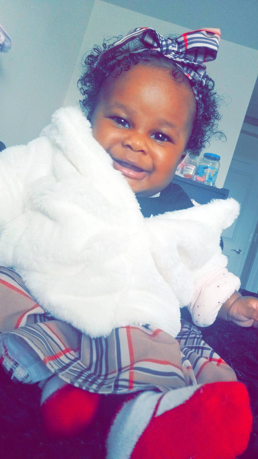 Me' Lanie is registered to the contest to win money with this photo: baby, baby_toddler_clothing, cheek, child, comfort, electric_blue, eye, flash_photography, fun, fur, hairstyle, happy, iris, joy, person, room, sitting, sleeve, smile, thumb