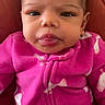 Kaliyah is registered to the contest to win money with this photo: baby, infant, child, pink_onesie, bird_pattern, tongue_out, face, head, sitting, expression, cute, indoors, portrait, clothing, warm_colors, young_child, person, soft_fabric, closeup, baby_fashion