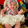 Ellie joined the competition — help win amazing prizes! baby, blanket, bow, cheeks, child, colorful, cute, fabric, feet, hands, happy, headband, indoor, infant, patterned_clothing, person, portrait, sitting, smiling, tutu