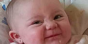 Ellie is registered to the contest to win money with this photo: baby, babywear, blanket, cheeks, closeup, clothing, cushion, cute, earring, expression, face, grin, head, indoor, infant, person, portrait, skin, smile, young_child