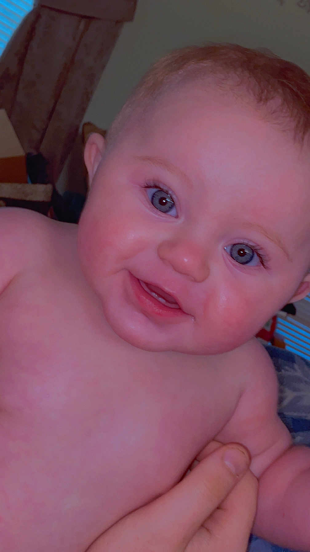Ellie joined the competition — help win amazing prizes! baby, child, smiling, face, blue_eyes, rosy_cheeks, hand, skin, portrait, close_up, indoors, person, cute, happy, infant, expression, human, young, holding, baby_skin