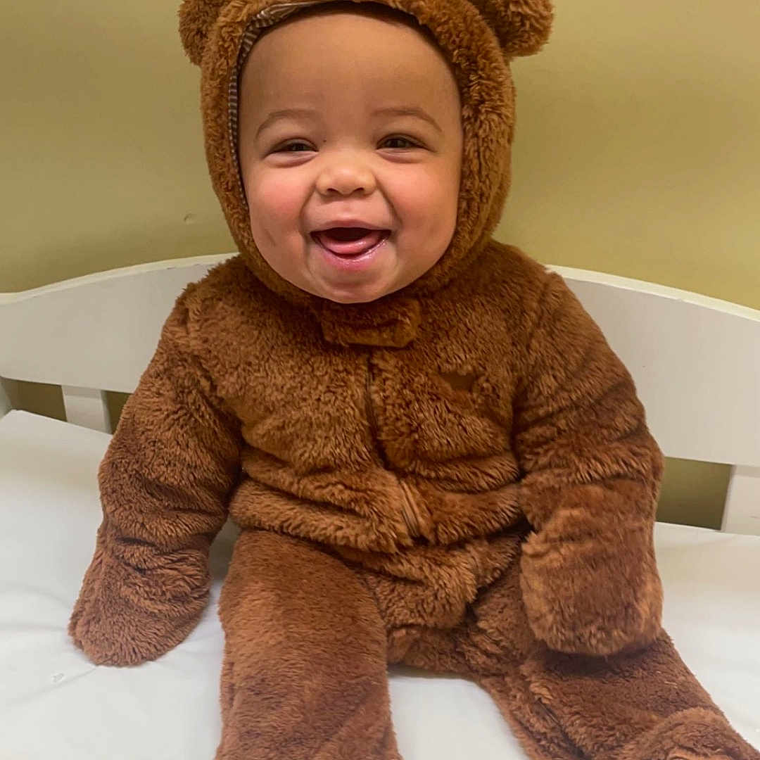 Elijah is registered to the contest to win money with this photo: baby, babylaughing, bed, clothing, coat, costume, crib, cushion, face, furniture, happy, hat, head, homedecor, infantbed, laughing, person, photography, portrait, smile