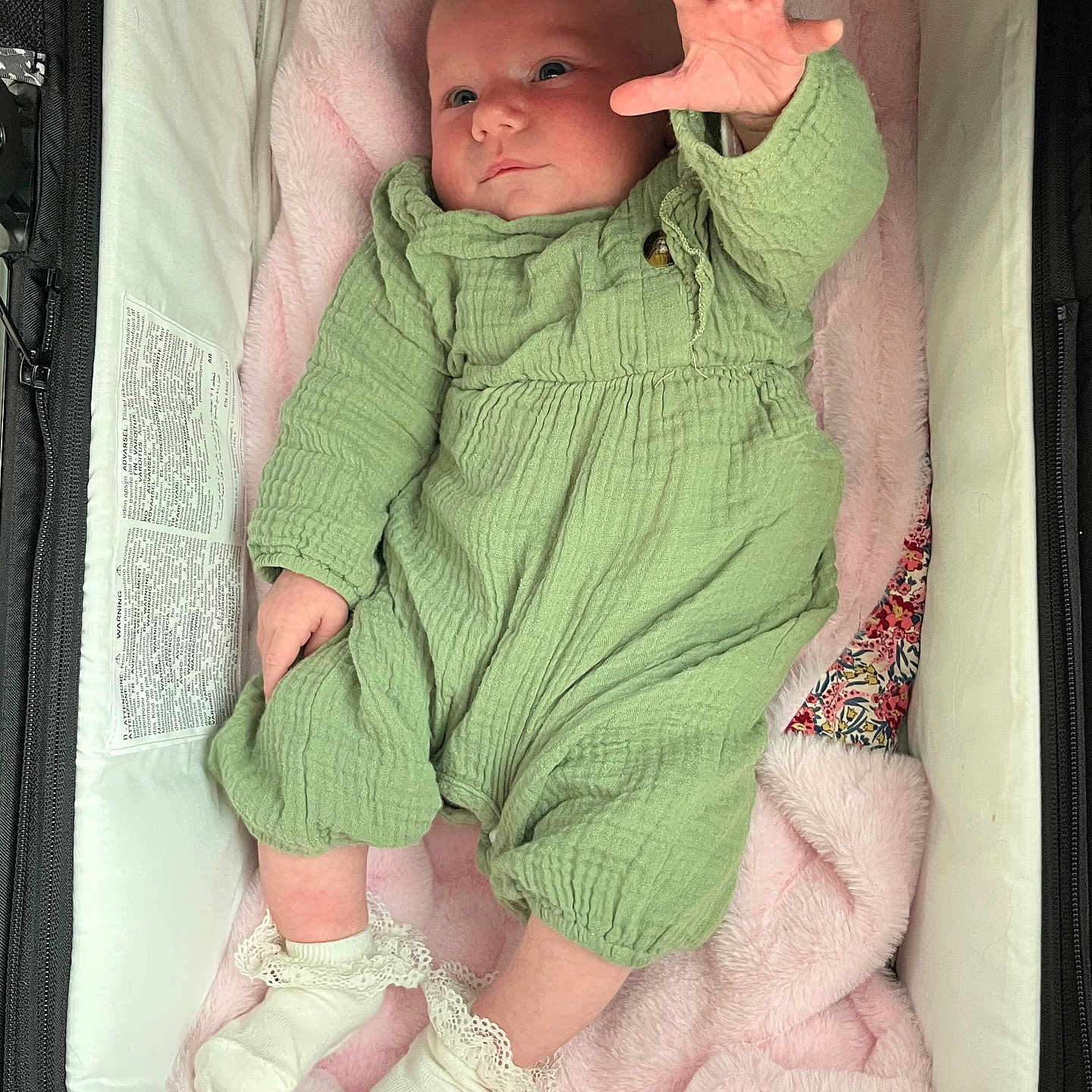 Tyméa a rejoint le concours — aidez-le/la à gagner de superbes lots ! baby, infant, green_outfit, blanket, bassinet, soft_texture, white_socks, hand, face, cute, newborn, cozy, lying_down, pink_blanket, clothing, person, indoor, sleeping_area, child, portrait