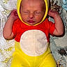 newborn, baby, sleeping, onesie, yellow, red, hood, bear_ears, blanket, animal_print, cute, infant, child, soft, cozy, peaceful, resting, portrait, indoors, clothing