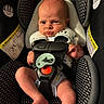 baby, newborn, car_seat, infant, straps, serious_face, indoors, child, seat_belt, clothing, sitting, cute, person, head, legs, foot, safety, warning_label, black, white