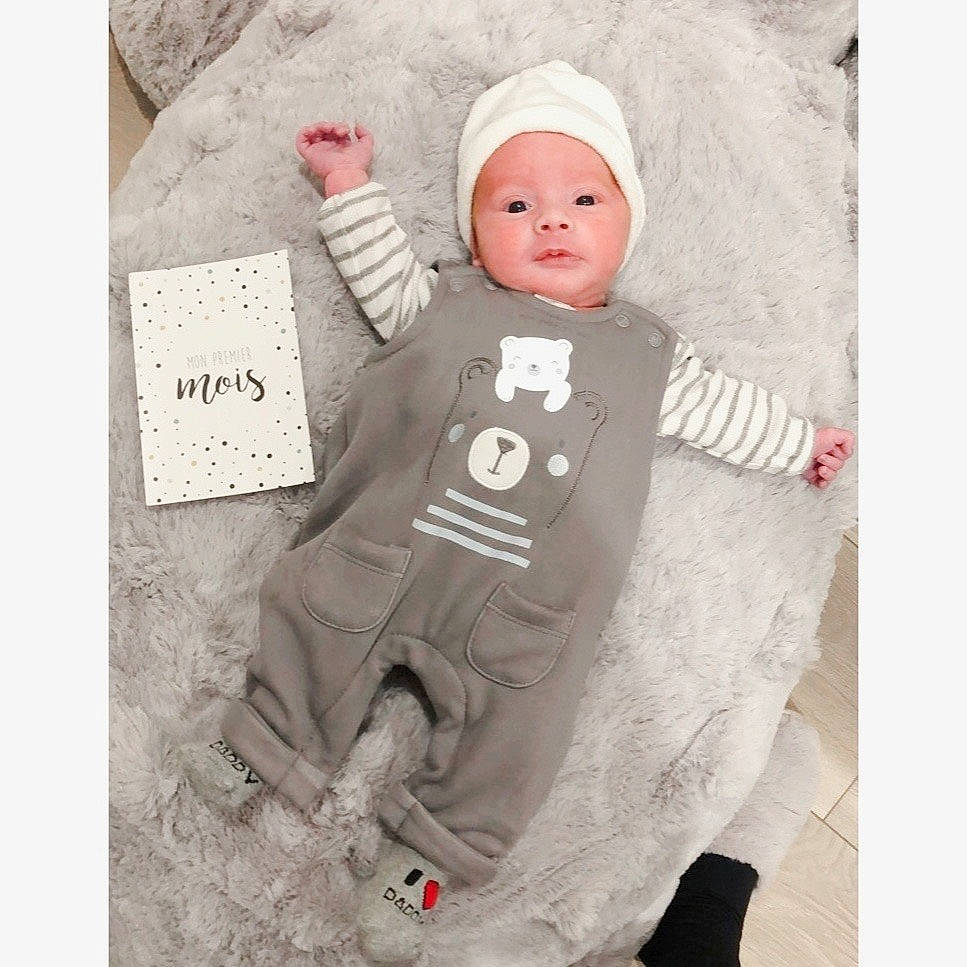 Swann participe au concours pour gagner de l'argent avec cette photo : art, astronaut, baby, baby_products, baby_sleeping, baby_toddler_clothing, cap, carmine, child, costume_hat, fictional_character, fur, gesture, happy, headgear, headwear, linens, person, sitting, sleeve