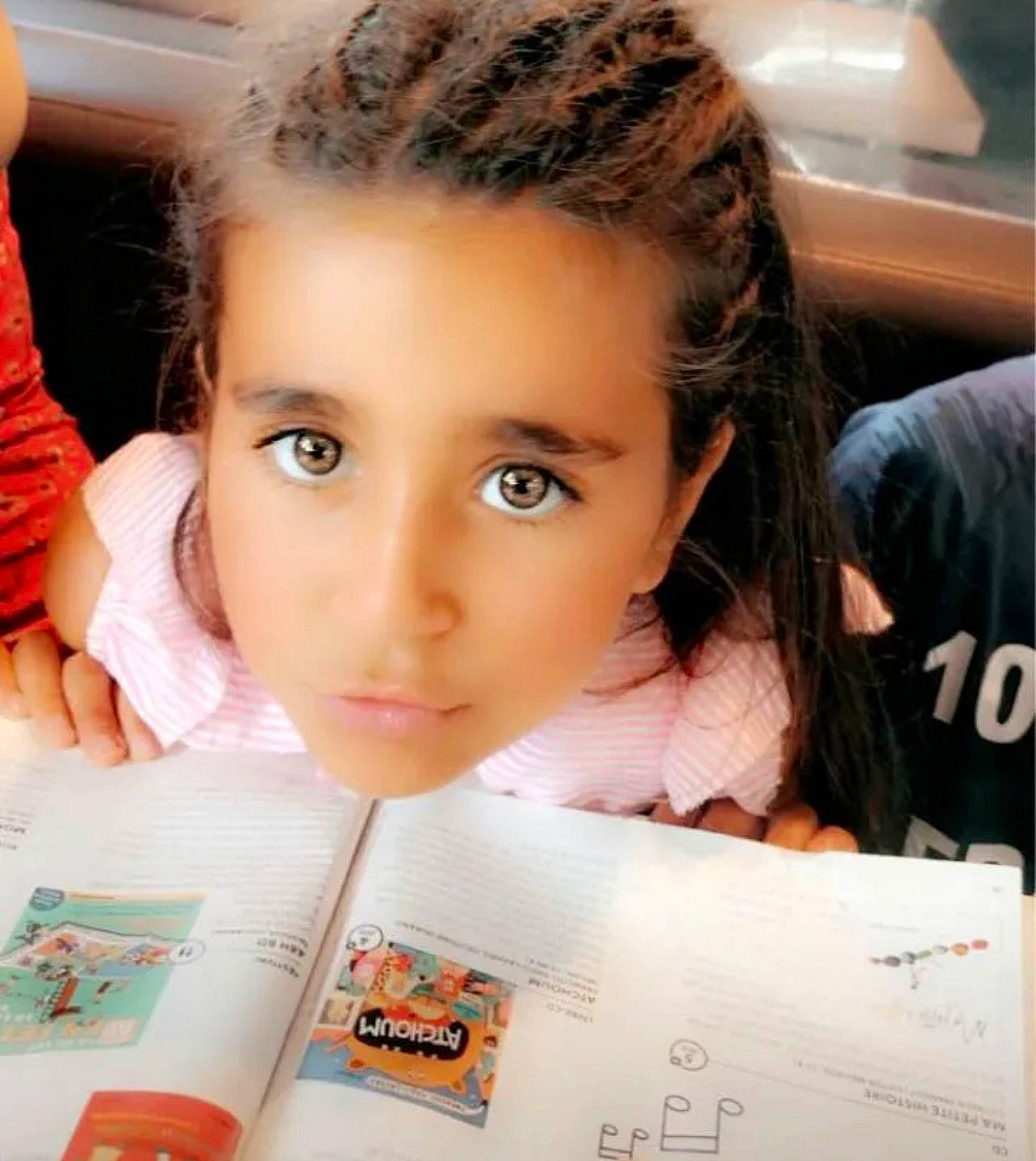 Tayana participe au concours pour gagner de l'argent avec cette photo : beauty, black_hair, book, cheek, child, ear, eyelash, font, forehead, fun, happy, learning, lip, nose, person, photograph, reading, room, skin, snapshot