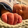 baby, newborn, sleeping, infant, hand, fingers, close_up, blanket, onesie, sleeve, soft_texture, cozy, peaceful, portrait, indoor, bed, face, pinky, macro, shallow_depth_of_field