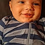 Ezekiel is registered to the contest to win money with this photo: baby, infant, smiling, face, close_up, portrait, onesie, striped_clothing, zipper, cheeks, eyes, mouth, skin, head, lying_down, blanket, soft_lighting, happy, cute, indoor