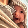 Kai Lovato joined the competition — help win amazing prizes! baby, infant, child, face, eyes, smiling, open_mouth, portrait, blanket, swaddled, hood, fabric, cozy, indoor, bed, bedding, close_up, happy, cuddled, photography