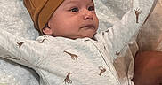 Kai Lovato joined the competition — help win amazing prizes! baby, infant, child, portrait, lying_down, smiling, wide_eyes, hat, beanie, onesie, giraffe_pattern, blanket, bed, bedding, pillow, indoor, cozy, cute, arms_raised, closeup