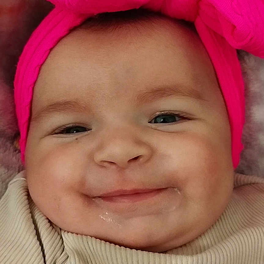 Inaya participe au concours pour gagner de l'argent avec cette photo : accessories, baby, bodypart, bonnet, clothing, face, finger, hand, happy, hat, head, headband, mouth, newborn, person, photography, portrait, purple, smile, teeth