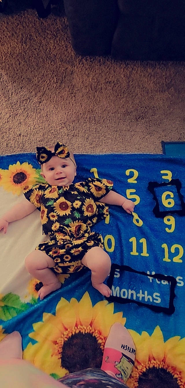 Madelyn joined the competition — help win amazing prizes! arm, baby, electric_blue, finger, flooring, flower, font, fun, hand, happy, headwear, human_leg, leg, leisure, pattern, person, petal, plant, recreation, sky