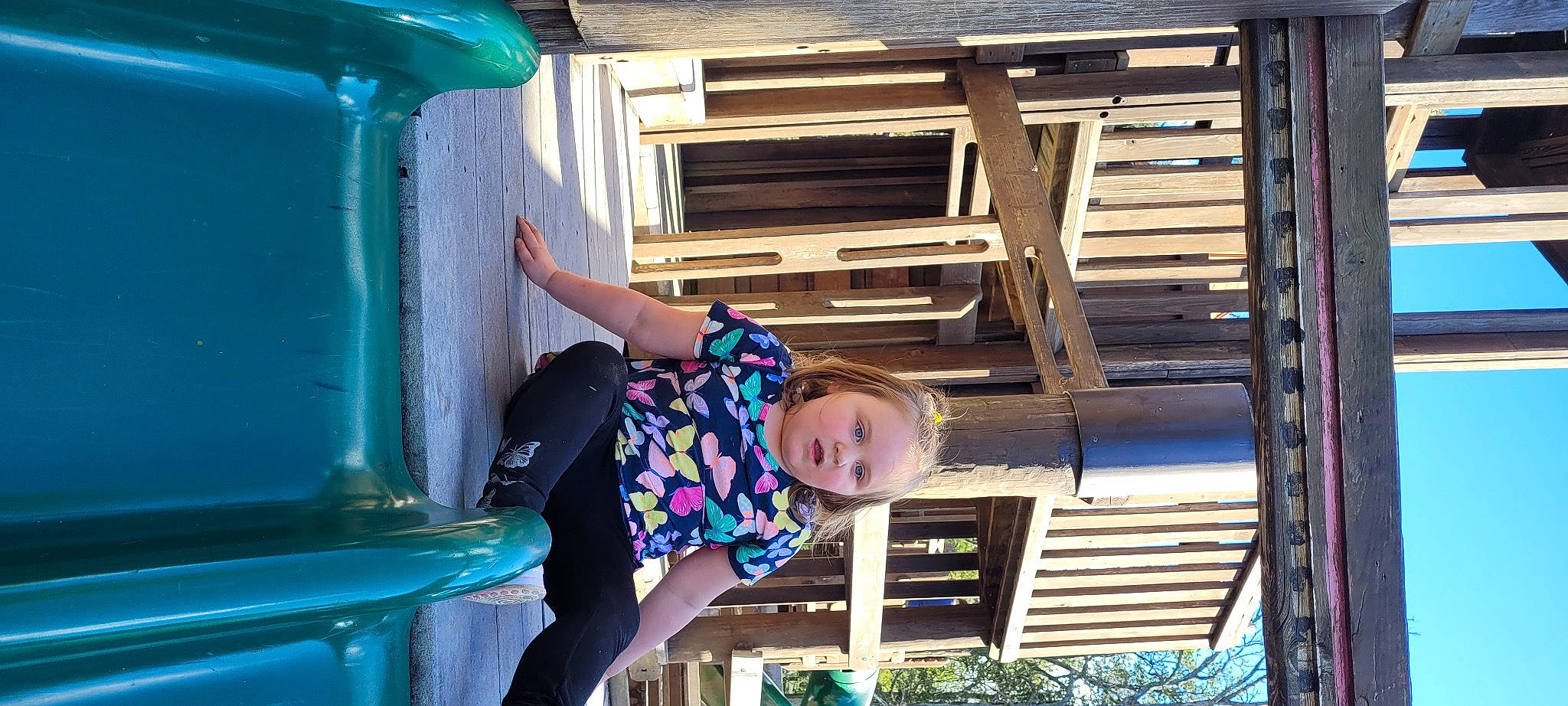 Lexi is registered to the contest to win money with this photo: blue, child, city, electric_blue, fun, green, happy, leisure, outdoor_play_equipment, person, plant, purple, recreation, smile, snapshot, summer, toddler, tree, vacation, white