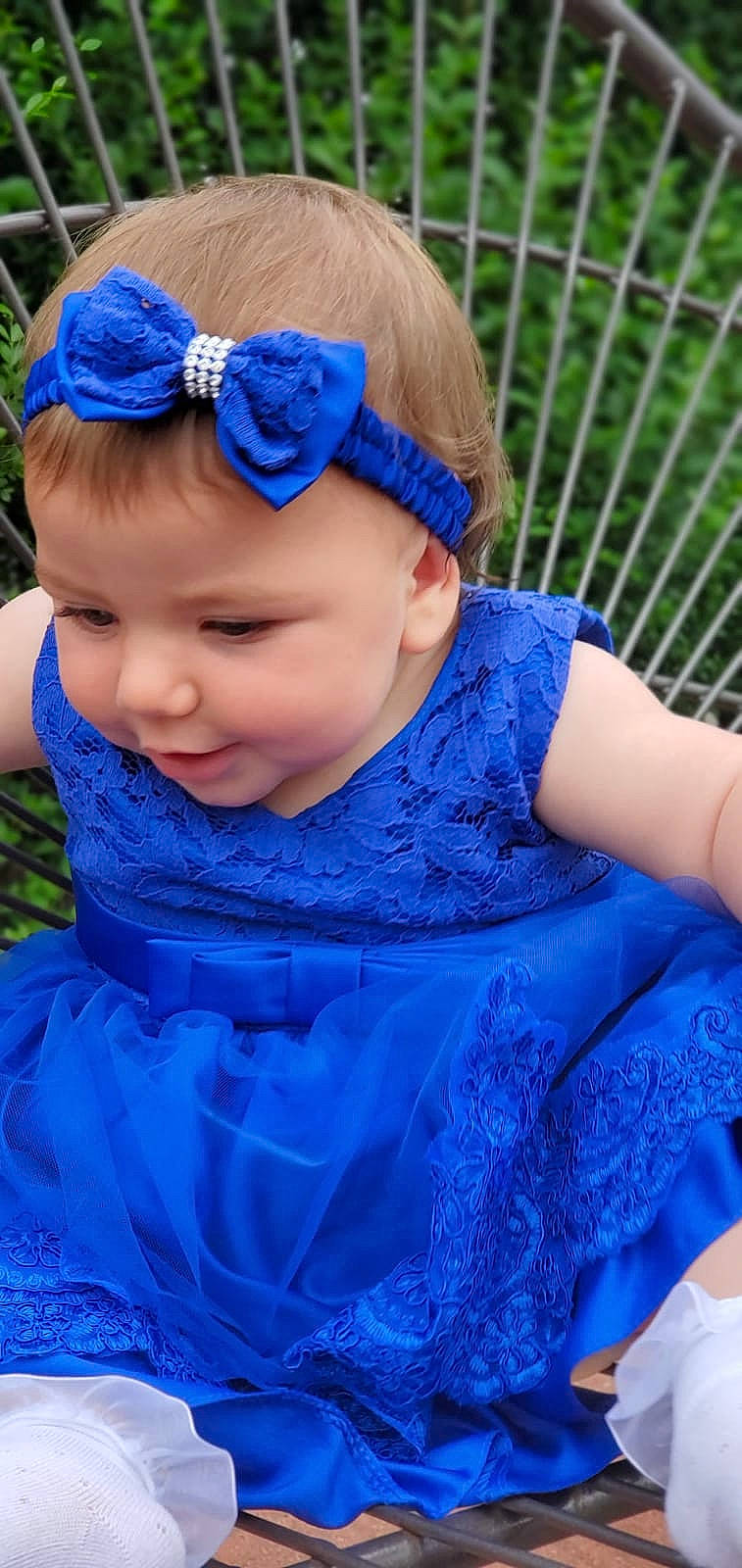 Anna is registered to the contest to win money with this photo: aqua, baby, baby_toddler_clothing, blue, cap, dress, electric_blue, fence, fun, goggles, grass, happy, headband, headgear, headpiece, person, pink, plant, purple, recreation