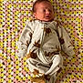 baby, newborn, sleeping, blanket, crocheted_blanket, onesie, lion_print, infant, child, soft_lighting, cozy, cute, peaceful, lying_down, indoors, fabric, pattern, warm, comfort, portrait