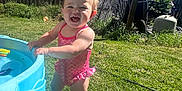 Evangeline joined the competition — help win amazing prizes! toddler, child, swimsuit, pink, water_table, grass, backyard, sunny, blue_sky, fence, house, barefoot, happy, smiling, outdoor, summer, play, young_child, daytime, nature