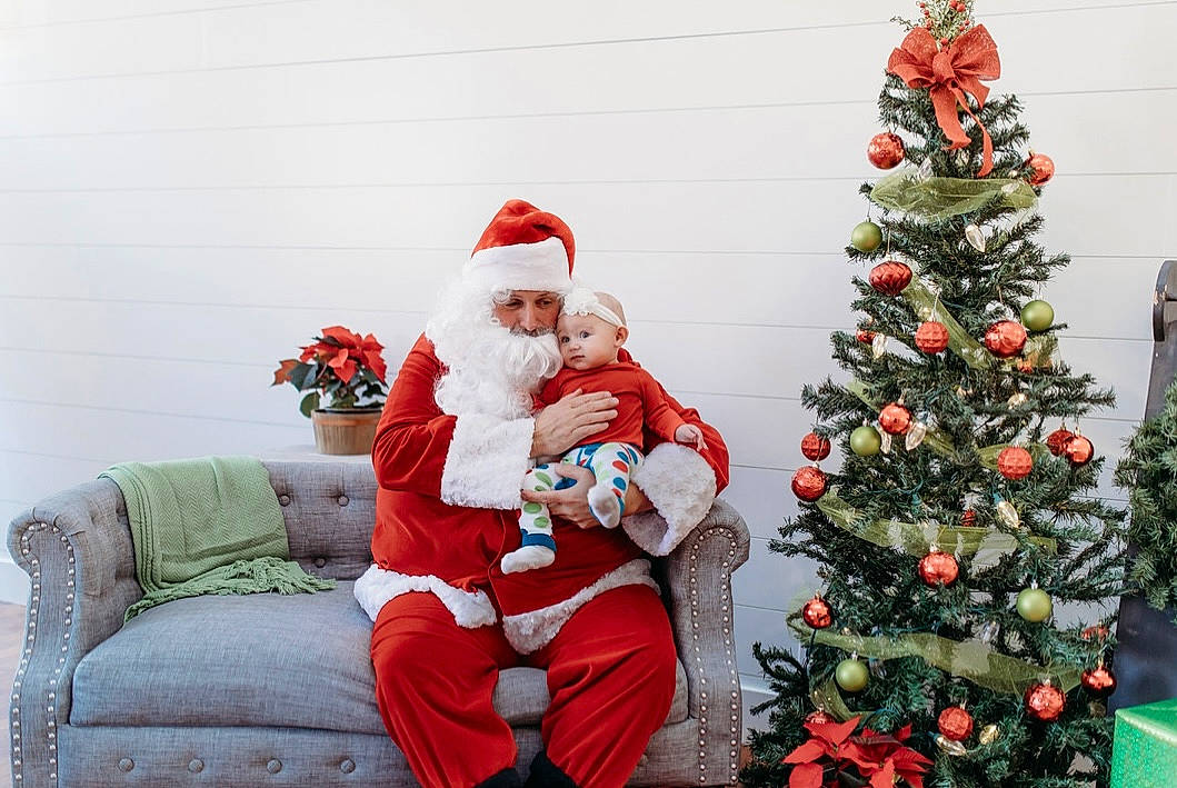 Ramona joined the competition — help win amazing prizes! christmas, christmas_decoration, christmas_ornament, christmas_tree, couch, evergreen, green, happy, hat, head, headwear, holiday, holiday_ornament, human_body, lap, mammal, ornament, person, plant, red