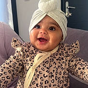 Syana participe au concours pour gagner de l'argent avec cette photo : baby, clothing, couch, curtain, cute, door, face, hand, happy, headwrap, indoor, infant, leopard_print, person, portrait, sitting, skin, smile, turban, young_child