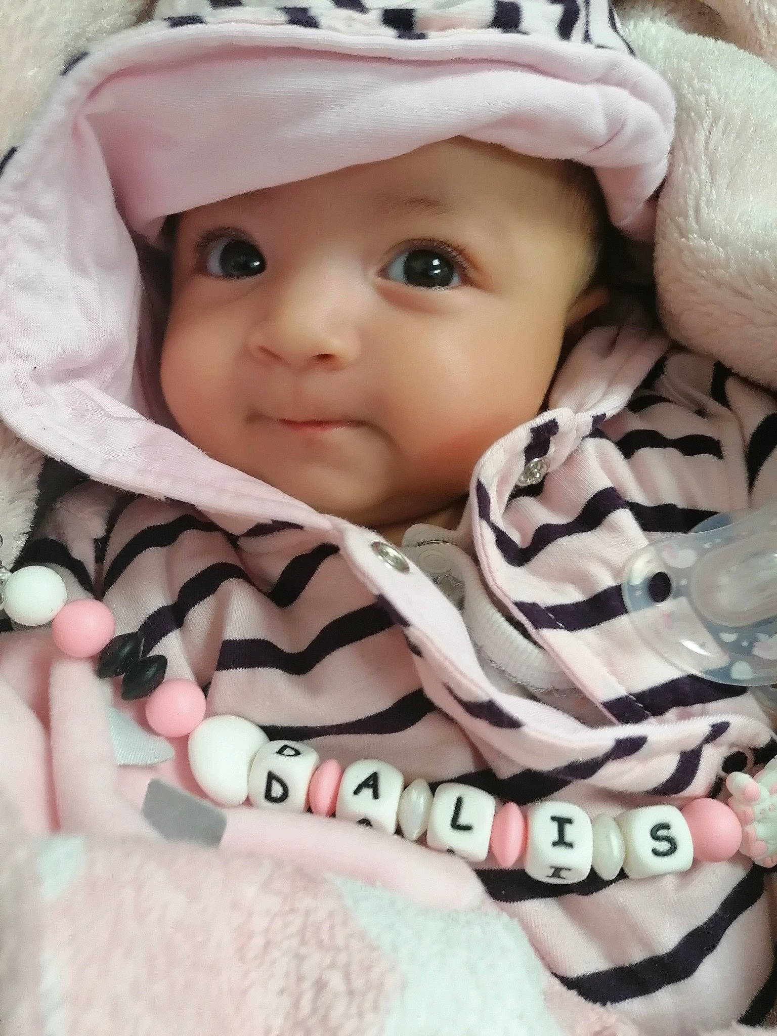 Dalis participe au concours pour gagner de l'argent avec cette photo : baby, baby_products, baby_safety, baby_toddler_clothing, cap, cheek, chin, comfort, eye, eyebrow, face, headwear, iris, linens, lip, nose, person, pink, skin, sleeve