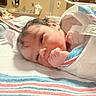 Miran is registered to the contest to win money with this photo: newborn, baby, infant, child, hospital, hospital_bed, blanket, swaddled, portrait, face, eye, hair, hand, fist, lying_down, sleeping, awake, indoors, medical, crib